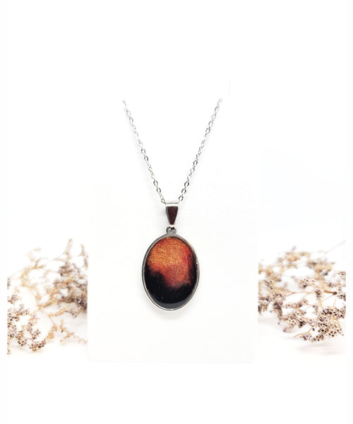 Black with Orange & Red in a Stainless-Steel Oval Pendant Necklace